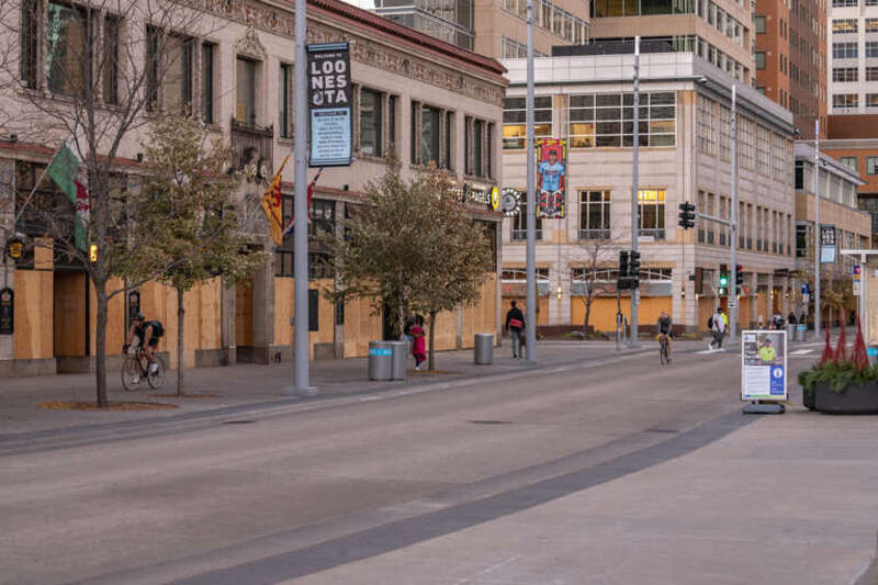 Bikers bike past boarded up buildings in downtown Minneapolis.
--
This photo is part of a continuing series covering the unrest and healing in Minneapolis following the May 25th, 2020 death of George Floyd. 
More photos: 
&amp;lt;a