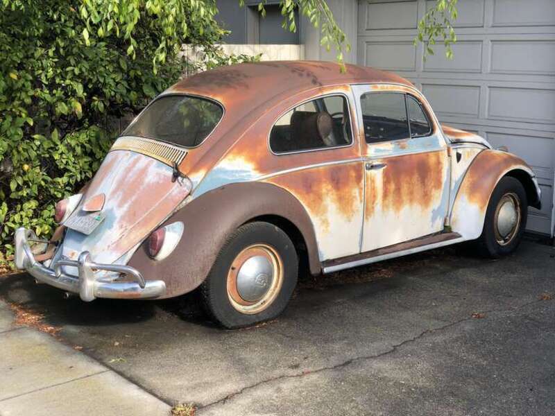 An old and rusted Volkswagen Beetle with a flat tire in a driveway along West Olive Avenue in Sunnyvale, Santa Clara County, California