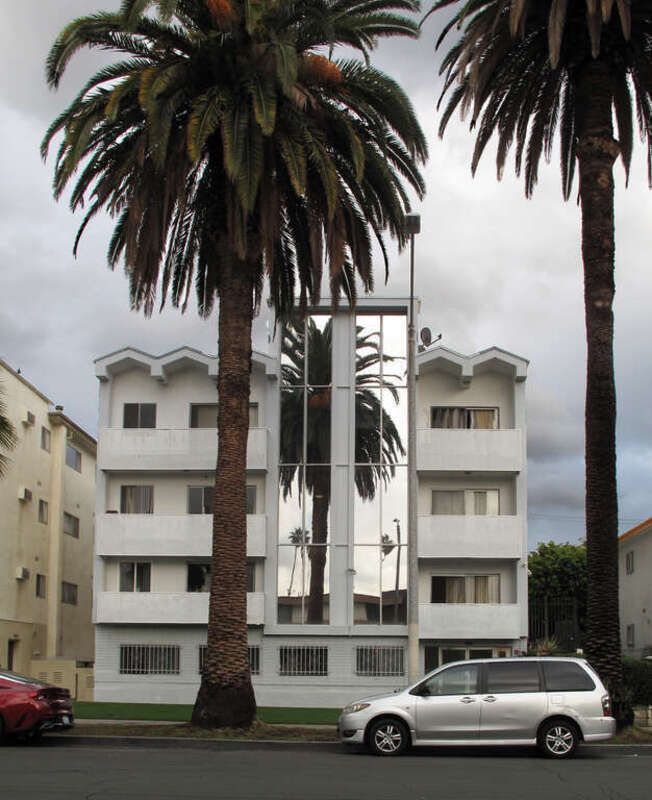Apartment building at 414 S. St. Andrews Place, Los Angeles, CA. The mirrored facade shows the palm tree in front as well as two Washingtonia filifera palms in the distance.
