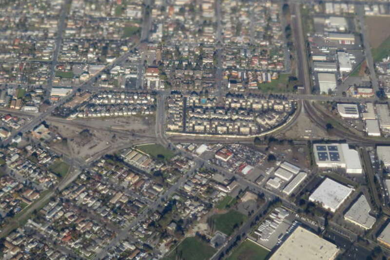 Aerial view of two railroad wyes in Newark, California in December 2018. The Coast Line runs left-to-right. At left, the former Dumbarton Cutoff splits and runs west to Redwood City. At right, a branch of the Niles Subdivision splits and runs east to