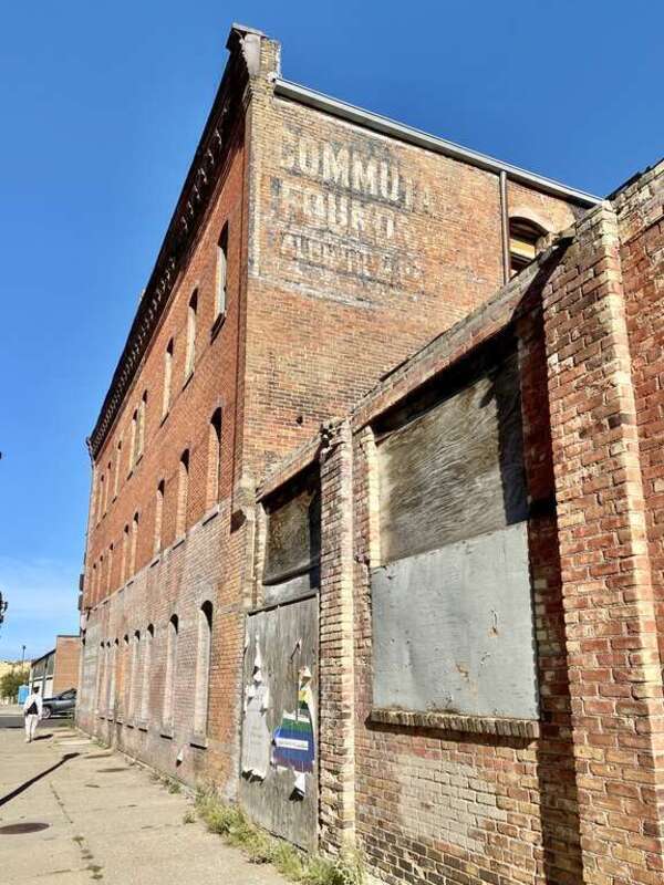 Built in 1884, this Italianate and Queen Anne-style building was formerly known as the American House Hotel, a boarding house.  The building features brick pilasters, a decorative stamped metal cornice, arched window openings with decorative