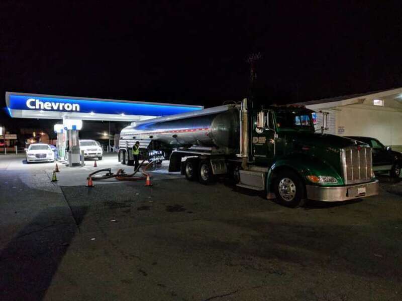 A tractor-trailer carrying a large fuel tank resupplies the underground tanks at a Chevron station in Campbell, California.