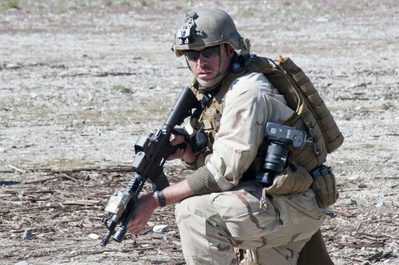 Petty Officer 1st Class Woody Paschall, mass communications specialist, provides security during vehicle debussing drills at Fleet Combat Camera Group Pacific's Winter Quick Shot 2011. Service members learn tactics to quickly and efficiently exit a