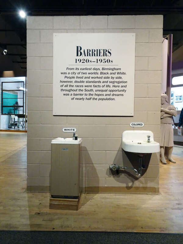 Deux lavabos. L'un, réservé aux blancs surmonte un petit meuble. Le second, réservé aux noirs est très basic.