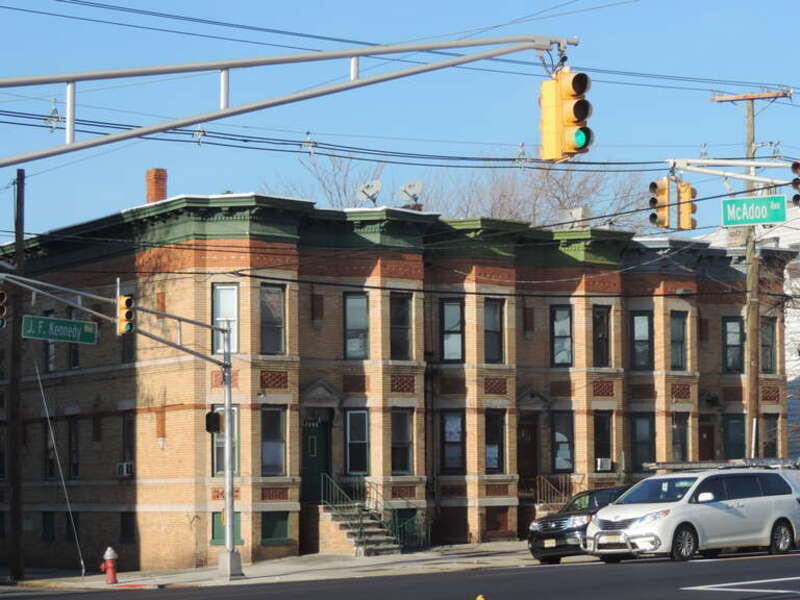 Looking north across JFK and McAdoo at row houses on a sunny afternoon