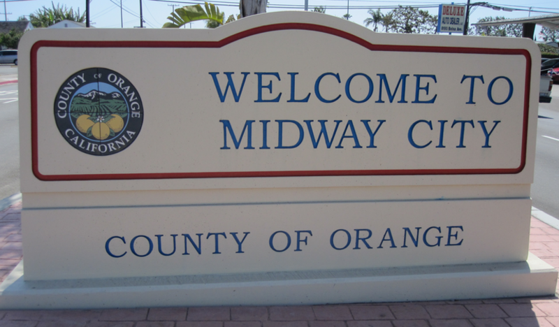 Photo of the Midway City, California welcome sign near 8121 Bolsa Ave, Midway City, CA 92655 introducing and welcoming visitors to Midway City.  The sign is located in the middle of Bolsa Avenue, just east of Jackson Street near both the Midway City