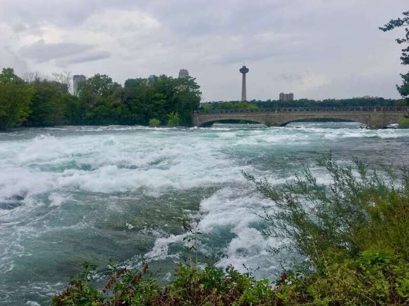 The roiling rapids of the Niagara River just upstream from the falls, as seen from the Shoreline Trail in Niagara Falls State Park, New York. This stretch of the river is known as &quot;Hell's Half Acre&quot;, for obvious reasons. The view is southwest toward