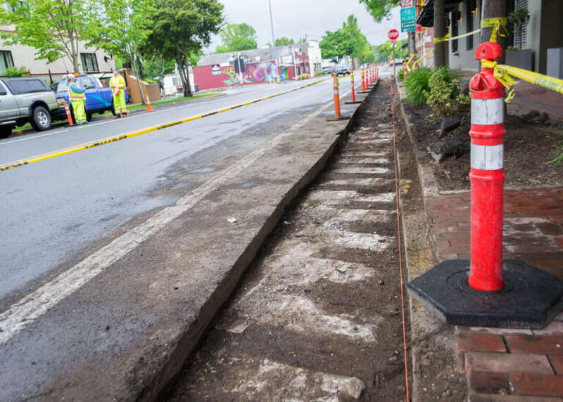 City workers uncover a section of railway ties beneath Fifth Avenue in Eugene, about two blocks from the Oregon Electric Railway Station. This view looks west between High and Pearl Streets.