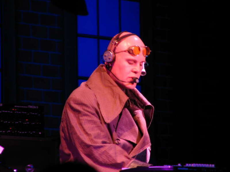 The trenchcoat is a classic Thomas Dolby item.