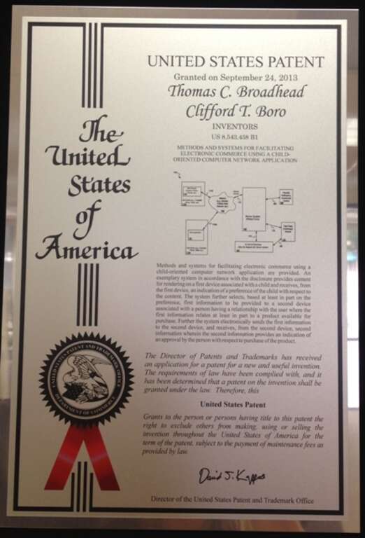 Photograph of framed U.S. Patent Office certificate for patent granted to Cliff Boro and Thomas Broadhead for their unique methods and systems for facilitating electronic commerce using a child-oriented computer network application.