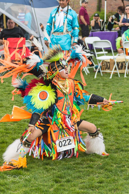 500px provided description: A young fancy feather dancer pins the tail.  Powwow songs have a tail at the end.  The best dancers stop on the very last beat, this young fellow nailed it and he knows it. [#boy ,#child ,#dancer ,#native american