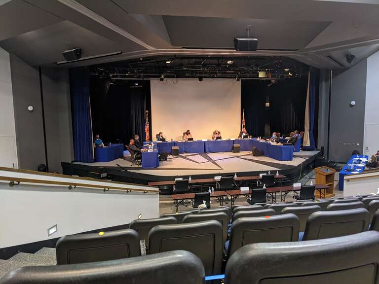 The Township High School District 211 Board of Education at its May 13, 2021 meeting at Hoffman Estates High School. Sitting at the long table on the stage, from left to right: Board Member Timothy Mc Gowan, Board Member Peter Dombrowski, Board