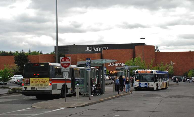 TriMet's Washington Square Transit Center, at Washington Square mall, in Tigard, Oregon. The buses at the transit center consist of a 1992 Flxible Metro and a 2009 New Flyer D40LFR. At the time of the picture, the D40LFR was TriMet's newest type of