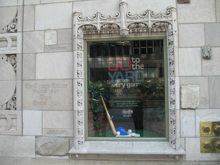 Tribune Tower Wall.  The window has a mock-up of the ivy at Wrigley Field with a poster advertising the Chicago Cubs baseball games on 720 WGN.  Tribune, owners of WGN, also owned the Cubs and Wrigley Field until 2009.  Surrounding the window