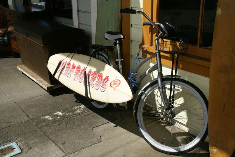 Surf board and bicycle at Ponahawai Street in Hilo, Hawwaii, Hawaii, USA
