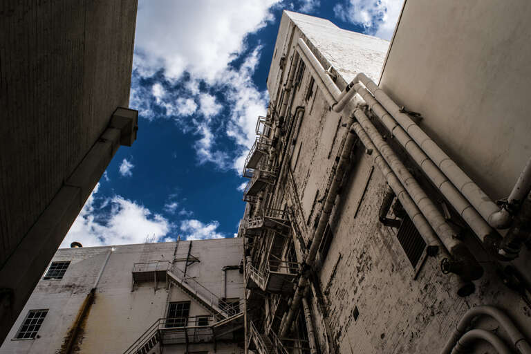 500px provided description: Alley Daze [#sky ,#city ,#blue ,#clouds ,#old ,#urban ,#architecture ,#cityscape ,#building ,#alley]