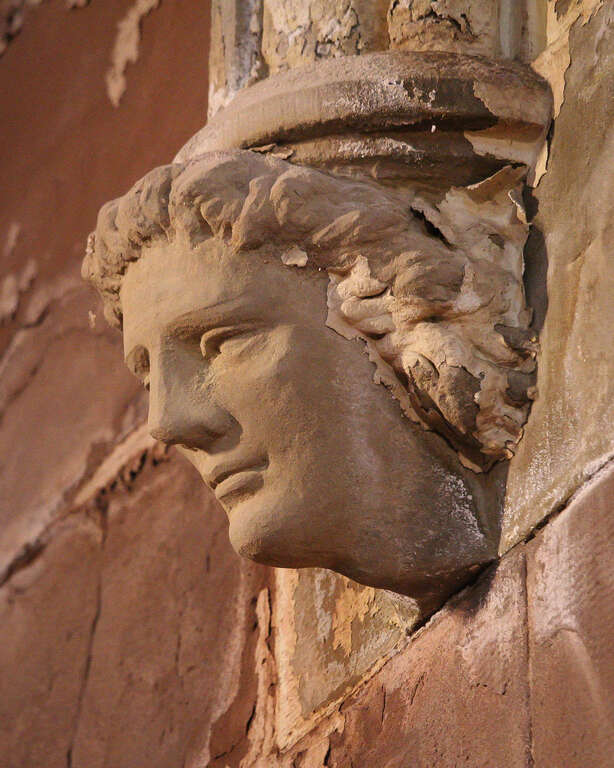 500px provided description: Two of these are at the base of an arch at St. Stephen Memorial Church in Lynn, MA.  He seems amused for a head decoration in a church. [#church ,#building ,#statue ,#head ,#arch ,#stone ,#sculpture ,#spirituality