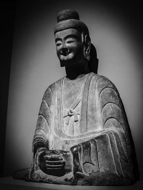 500px provided description: Buddha from the Northern Wei dynasty in China (385-535 A.D.). In the Honolulu Museum of Art in Honolulu, Hawaii. [#travel ,#black and white ,#usa ,#art ,#face ,#monochrome ,#dark ,#stone ,#sculpture ,#hawaii ,#china
