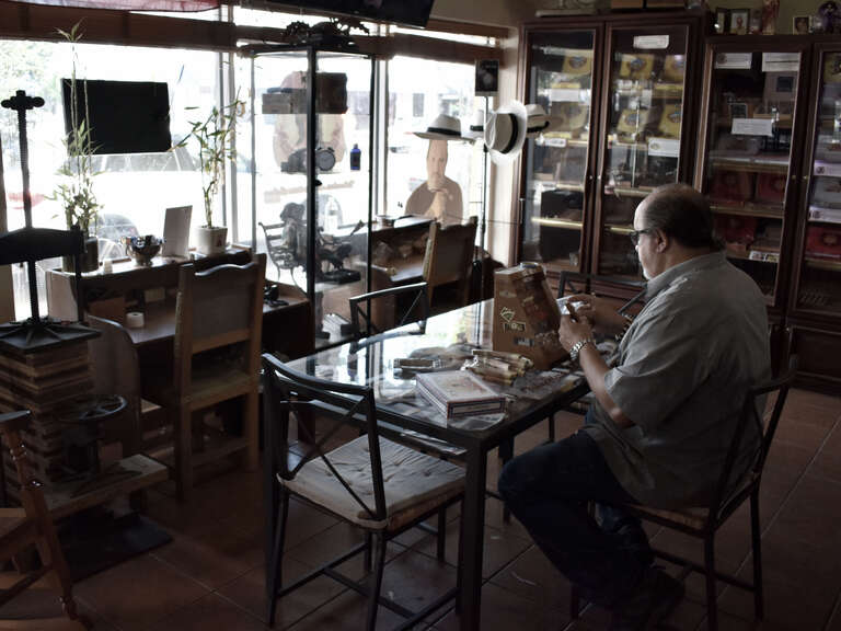A cigar salesperson prepares his product for sale in the Little Havana neighborhood of Miami.