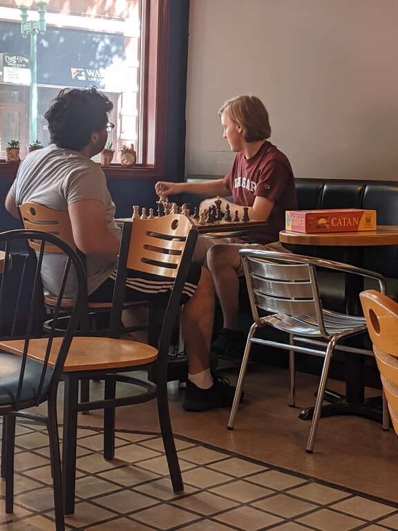 Two young men play chess at Taylor Books, 226 Capitol Street in downtown Charleston, West Virginia on the Fourth of July.