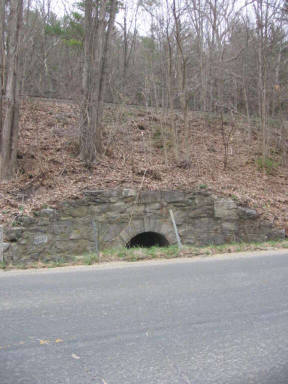 View of the stone culvert between Falls Village and Lime Rock stations on the Housatonic Railroad in Canaan, Connecticut.  This view shows the Warren Turnpike and rails a bit better than the other view.