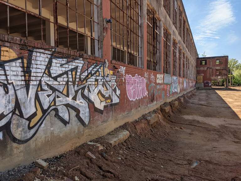 Spray-painted graffiti on the side of the Mock, Judson, Voehringer Company Hosiery Mill that faces Hiatt Street, taken in 2021
