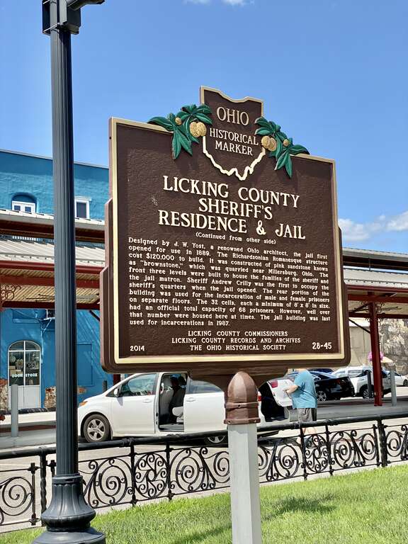 Built in 1889, this Richardsonian Romanesque Revival-style building was designed by Joseph W. Yost to serve as the jail and Sheriff’s residence for Licking County, Ohio.  The building features a rusticated brownstone exterior with limestone trim, a