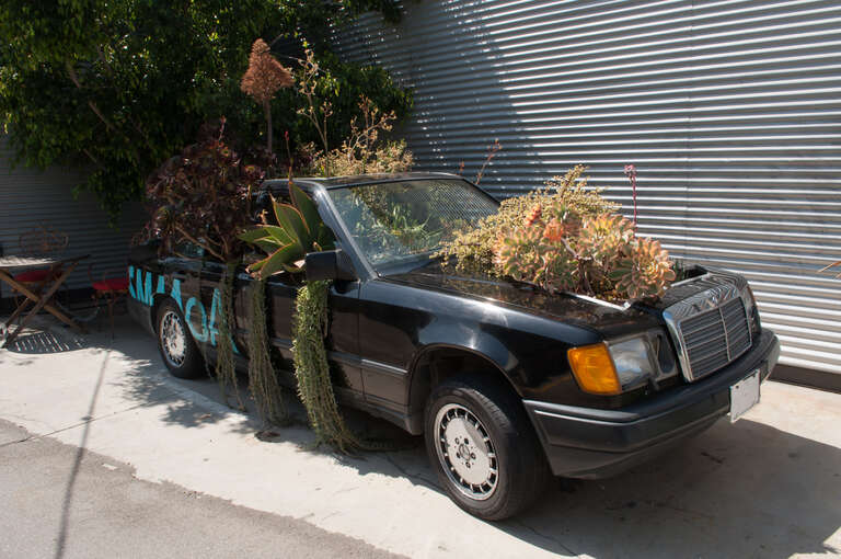 This 1990 Mercedes-Benz 300E is an arts installation just outside the doors of Santa Monica Museum of Art.
With Southern California's lifestyle and development being dominated by automobiles, especially pricey, vain imports like this Mercedes-Benz,