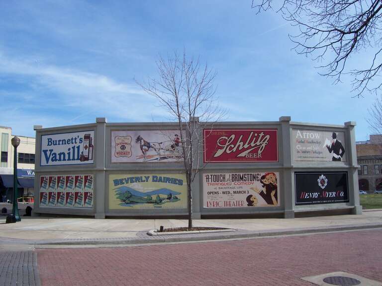 Fake advertisement signs to hide some modern benches in the city square.