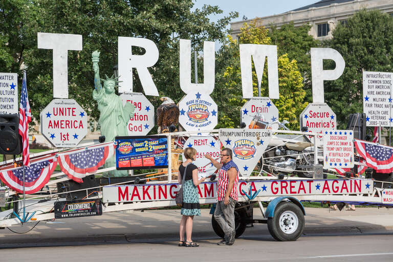 A reporter interviews Robert Cortis in front of his &quot;Trump Unity Bridge&quot; trailer at the University of Iowa campus in Iowa City, Iowa, on August 18, 2017.