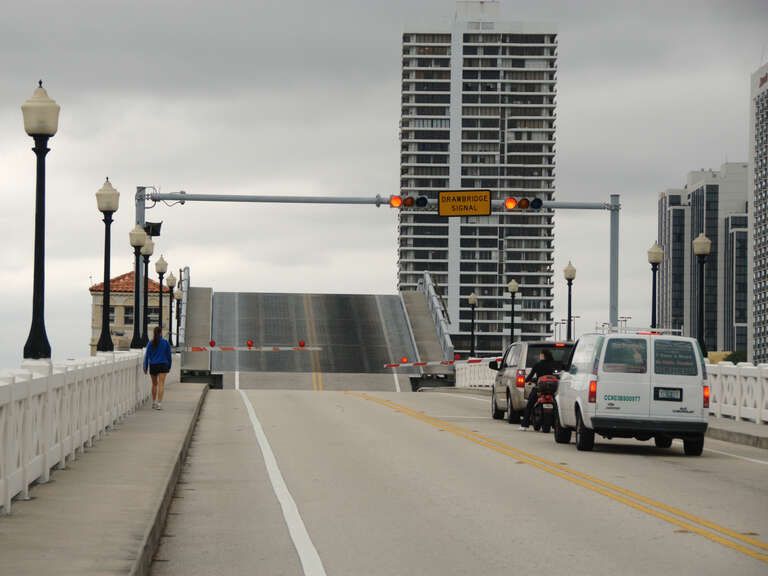 The west bridge of two very similar bascule-type drawbridges (both built in 1927) on the Venetian Causeway, connecting Miami and Miami Beach, through the Venetian Islands, in Miami Beach, Florida.  In this views, cars and pedestrians are waiting