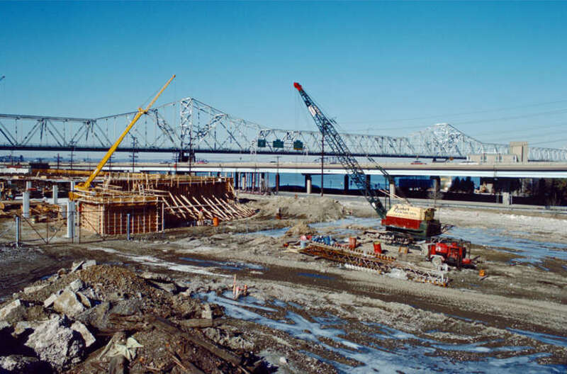 Looking NW from near what will later be the intersection of Witherspoon St. and Bingham Way.
Witherspoon St. parking garage under construction.
I-64 and Clark Bridge in distance.
Ohio River mile 604.
Louisville, Kentucky.
January 1988.
File #