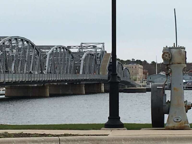 The Sturgeon Bay Bridge is a 1931 Bascule Bridge in the eponymous city that formerly carried Highway 42/57, and now carries their business routes over the bay of Sturgeon Bay. In this photo, this bridge was in open position.