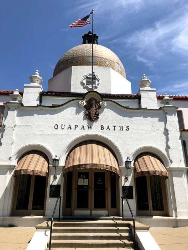 Front view of the Quapaw. Spanish style architecture with arched entry ways, an Indian motif, and a large tiled domed roof.
The Quapaw Bathhouse was originally built in 1922.
Keywords: Bathhouse Row; Quapaw Bathhouse; Historic building