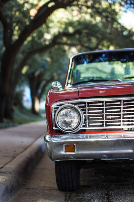 Cropped shot of a red vintage car parked by the curb