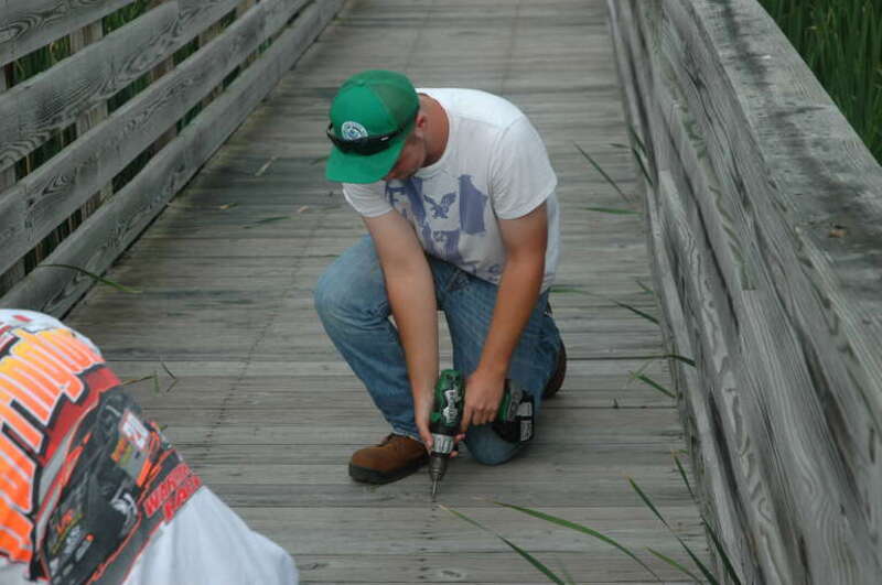 A YCC crew member repairs a boardwalk trail at Prime Hook National Wildlife Refuge.