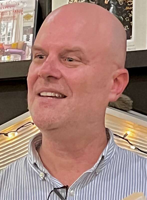 Author Andrew Maraniss in blue striped shirt with glasses hanging on collar