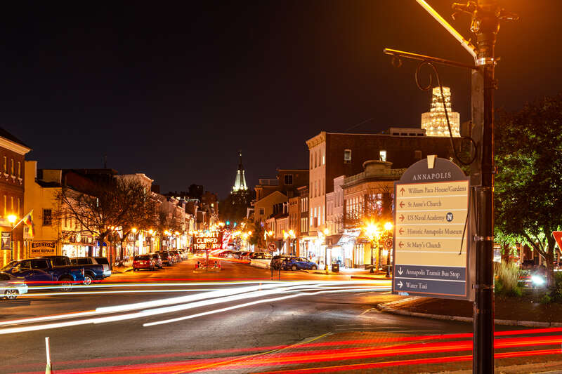 An evening view up Main St in Annapolis, MD. This is from the docks at Ego Aly off of the Chesapeake Bay. Up at the top of the street is St Anne's Church with the Maryland State House in view on the right. The State House dome is currently undergoing