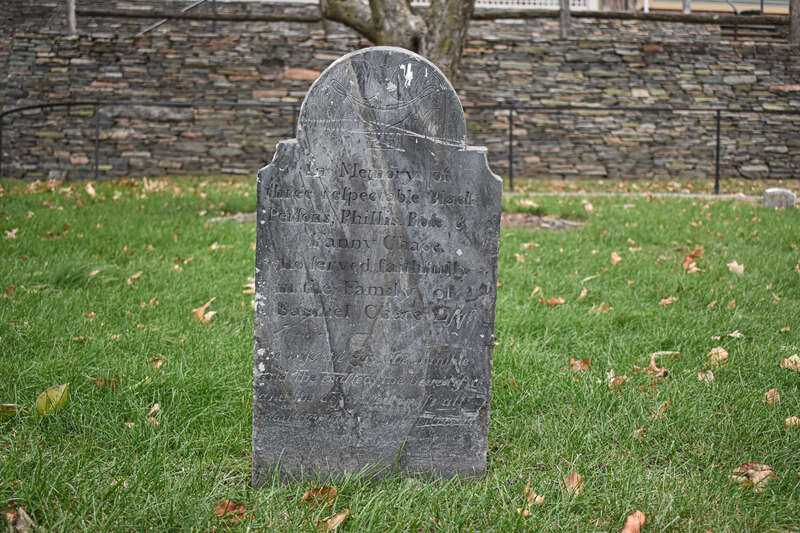 A headstone in the cemetery of the Cathedral of St. John in Providence RI marking the graves of three enslaved Black women: Phillis, Rose &amp;amp; Fanny Chace.
The text on the headstone reads: 

In memory of three respectable black persons, Phillis,