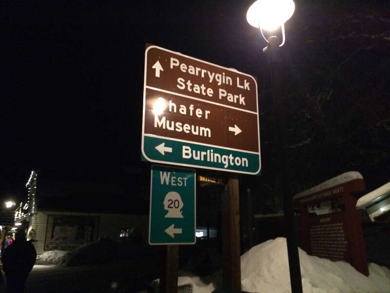 Road sign with directions to Pearrygin Lake State Park, Shafer Museum, and Burlington on Washington State Route 20 in Winthrop, Washington