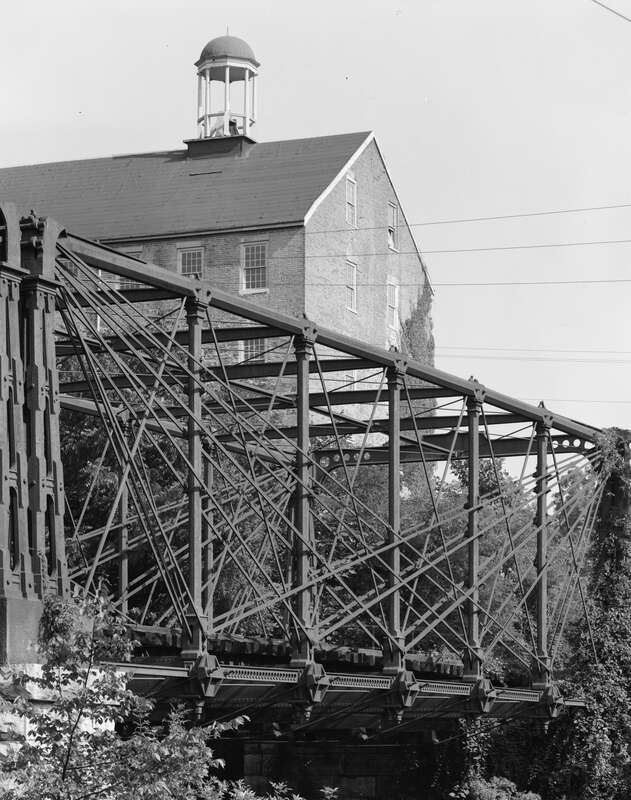 Bollman Truss Railroad Bridge at Savage, Maryland. General view of truss on east side of the bridge, with Savage Mill tower in the background.  Image cropped.