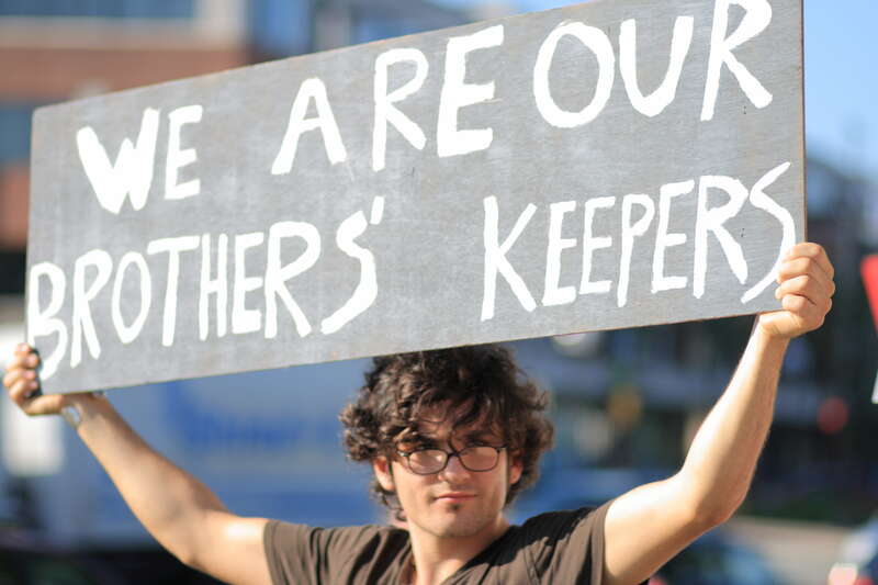 Young man with a sign that reads &quot;We are our brothers' keepers&quot; outside the West Hartford, Connecticut town hall before a health care reform town hall meeting with U.S. Representative John B. Larson on 2 September 2009.