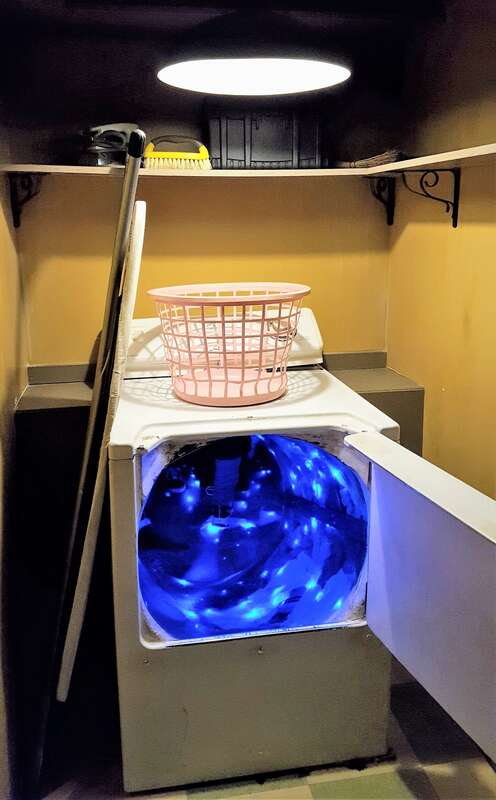 Washing machine leading to a light-filled tunnel/slide, part of the Meow Wolf House of Eternal Return installation in Santa Fe, New Mexico.