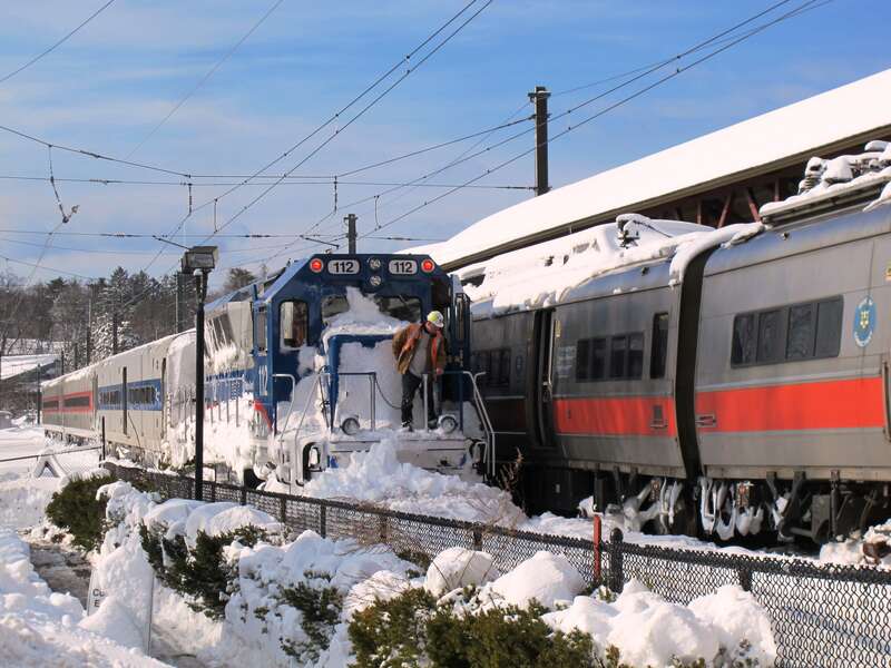 Metro-North locomotive 112 with a set of single-level cars next to a derailed string of M2 cars at New Canaan station in January 2011