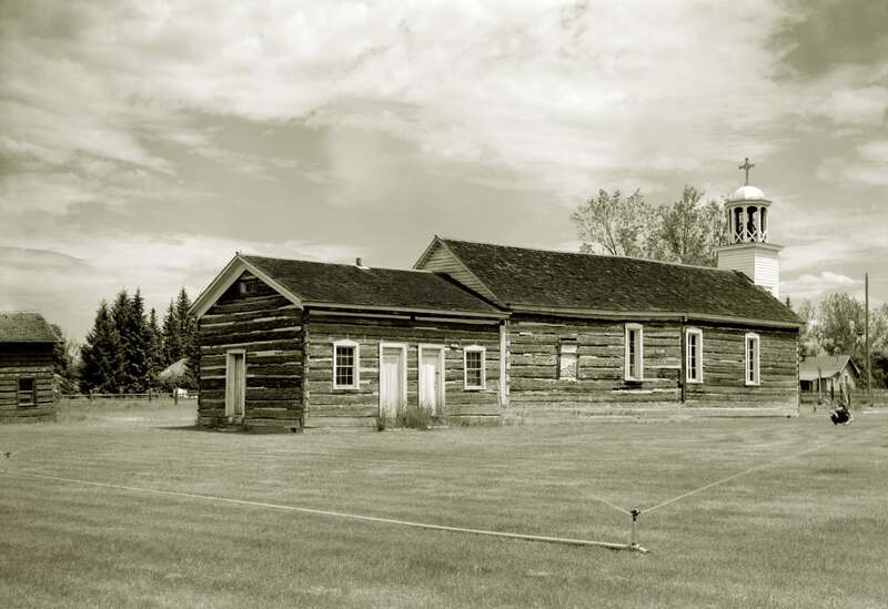 Southwestern view of St. Mary's Roman Catholic Mission, located along North Avenue in Stevensville, Ravalli County, Montana, United States.  Together with the attached pharmacy, visible on the far left, the church (built in 1866) is listed on the
