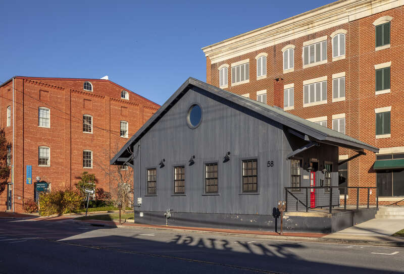 Carroll Street freight depot, Maryland, USA, with the Sky Stage sign in shadows on the street and the Delaplaine Visual Arts Center beyond