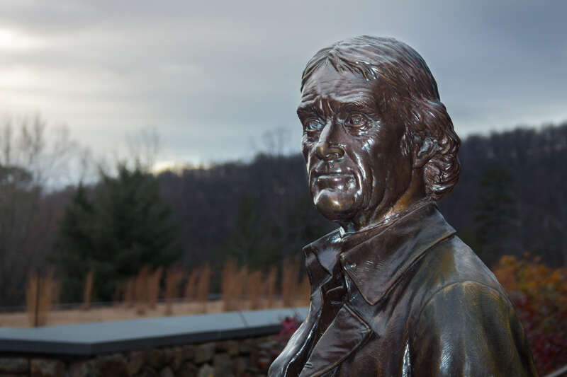 The sun begins to set on the statue of Thomas Jefferson at Monticello