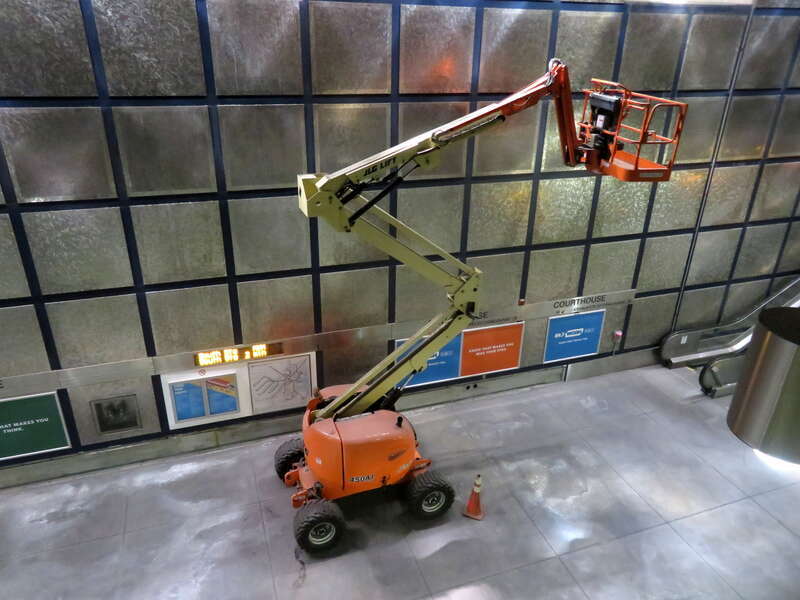 An articulated boom lift on the Courthouse station in December 2019. The lift is kept at the station for use in removing wall panels for maintenance.