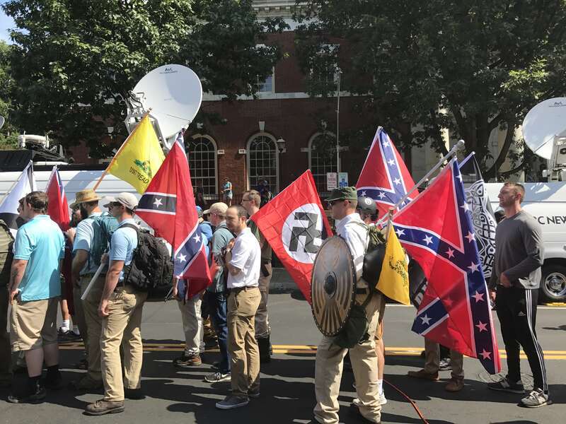 Alt-right members preparing to enter Emancipation Park holding Nazi, Confederate, and Gadsden &quot;Don't Tread on Me&quot; flags.
