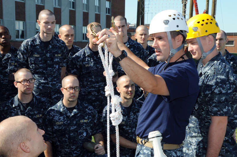 NEWPORT, R.I. (Sept. 22, 2010) Chief Aviation Structural Mechanic Adam Bowie, a recruit division commander and facilitator for the High Ropes Course at Officer Training Command, shows a class from Officer Candidate School how to properly attach the